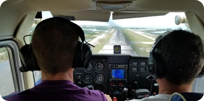 Student pilot celebrating beside a training airplane