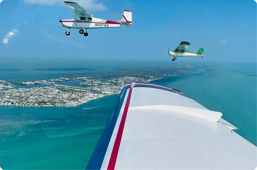 Student celebrating a flight training achievement beside an airplane